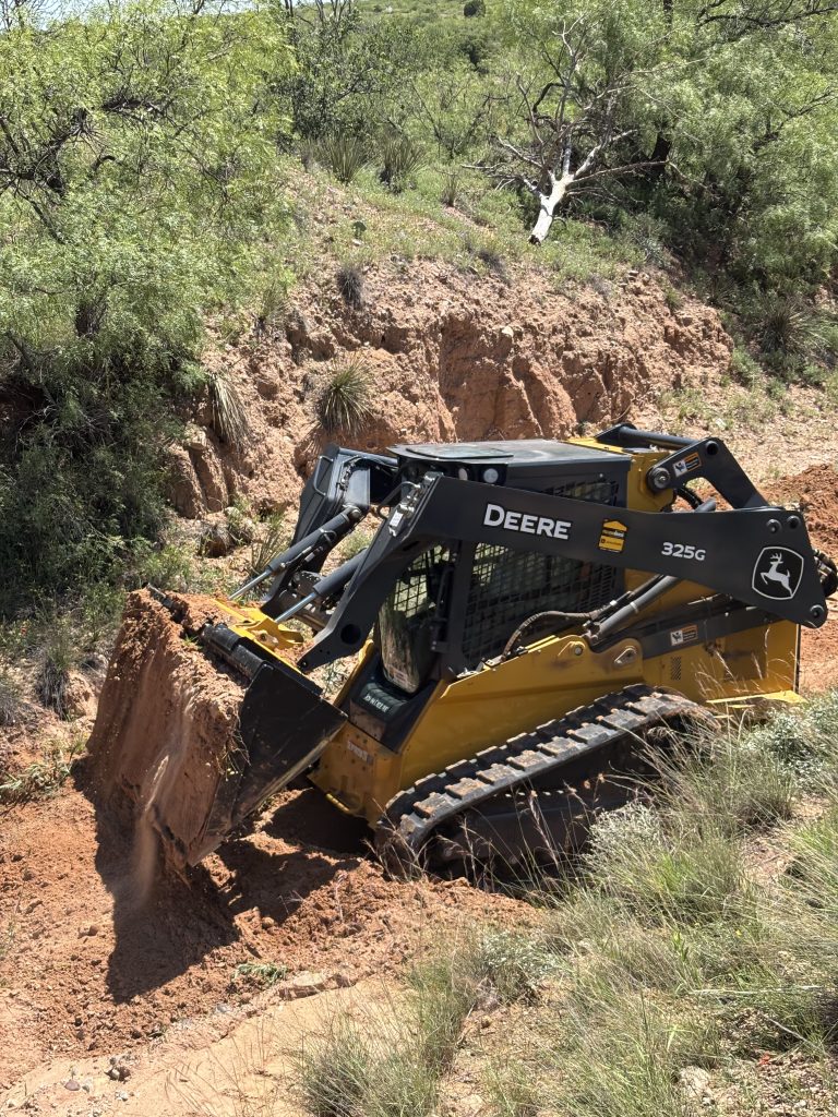 A John Deere Compact Track Loader moving dirt in agriculture and construction applications
